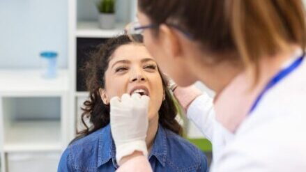 Doctor-examining-patient’s-tonsils-prior-to-tonsillectomy